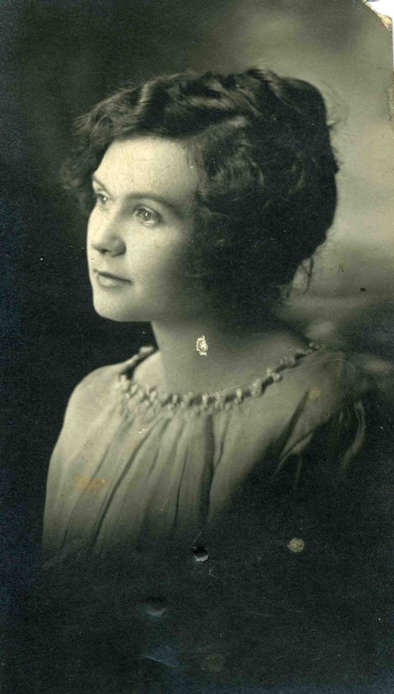 Portrait photo of a young woman from the early 20th century (1900s?  1910s?) in partial profile gazing off to left. 