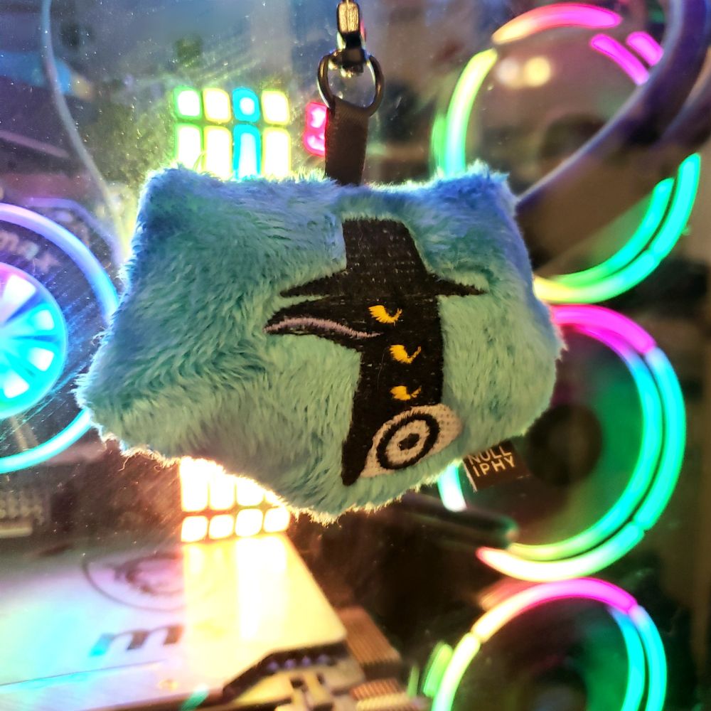 the back of the plush keychain, featuring an embroidered smug Sussy from KPop Demon Hunters, made by Paige Grigg / NULLIPHY