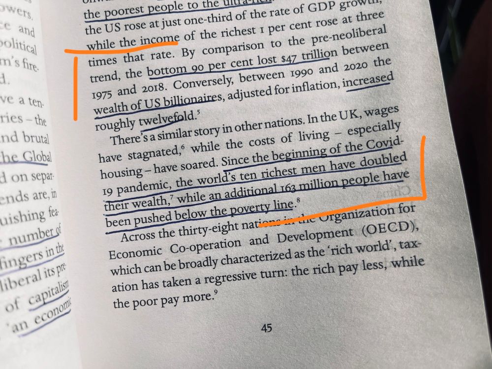 A close-up photo of a book page discussing economic inequality. Key sections are underlined in blue and highlighted with orange brackets. The text notes that from 1990 to 2020, the wealth of US billionaires increased twelvefold, while the bottom 90 percent lost $47 trillion. It also states that since the beginning of the Covid-19 pandemic, the ten richest men have doubled their wealth, while an additional 163 million people have been pushed below the poverty line.
