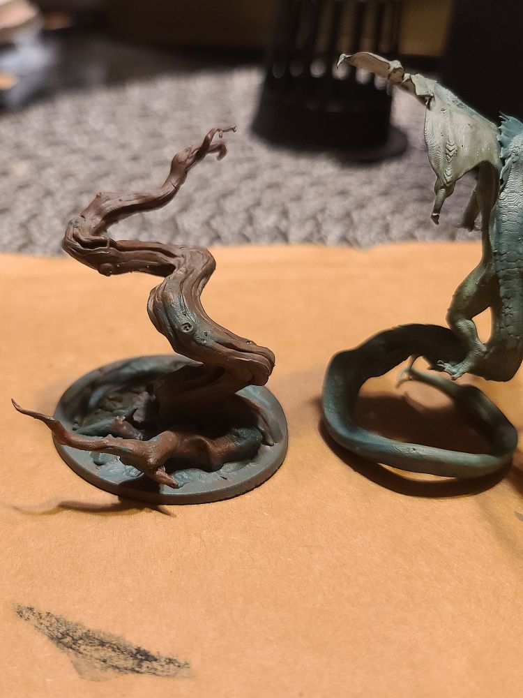 WIP of painting a miniature of a twisted tree and another creature with a long tail...