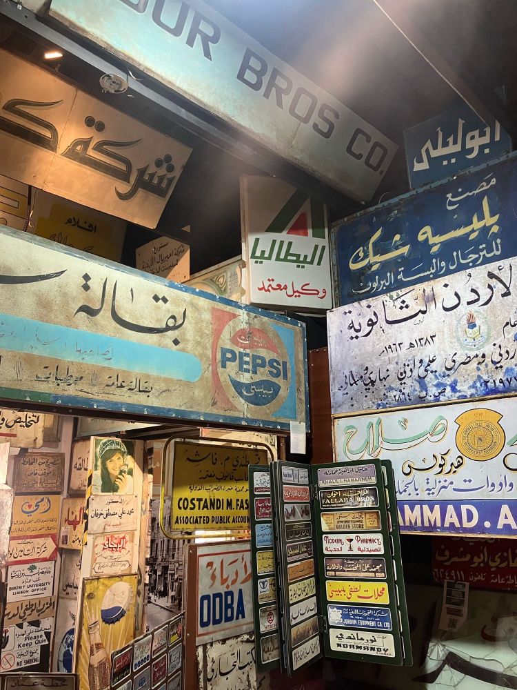 An interior of the sign museum in Amman: a jumble of hand painted signs mostly in Arabic 