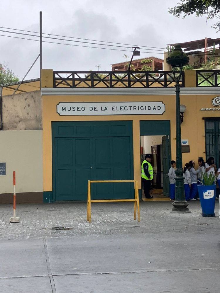 The exterior of the Museo de La electricidad in Lima - a low rise building painted yelllw with green shutters 