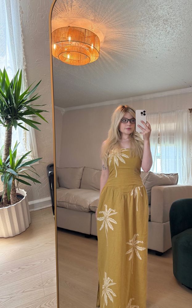 vada wearing a long yellow dress with palm trees on it
