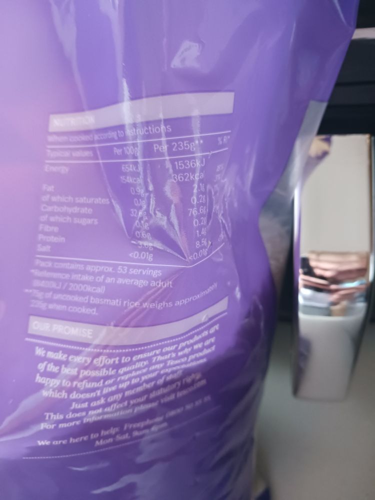 The nutrition label on a bag of rice. The numbers given are for cooked rice, per 100g and 235g, with a footnote stating that 235g of cooked rice is equivalent to 75g of uncooked rice.

Typical values, per 100g, per 235g
Energy, 654kj or 154kcal, 1536kj or 362 kcal
Fat, 0.9g, 2.1g
Of which saturates, 0.1g, 0.2g
Carbohydrate, 32.6g, 76.6g
Of which sugars, 0.1g, 0.2g
Fibre, 0.6g, 1.4g
Protein, 3.6g, 8.5g
Salt <0.01g, <0.01g