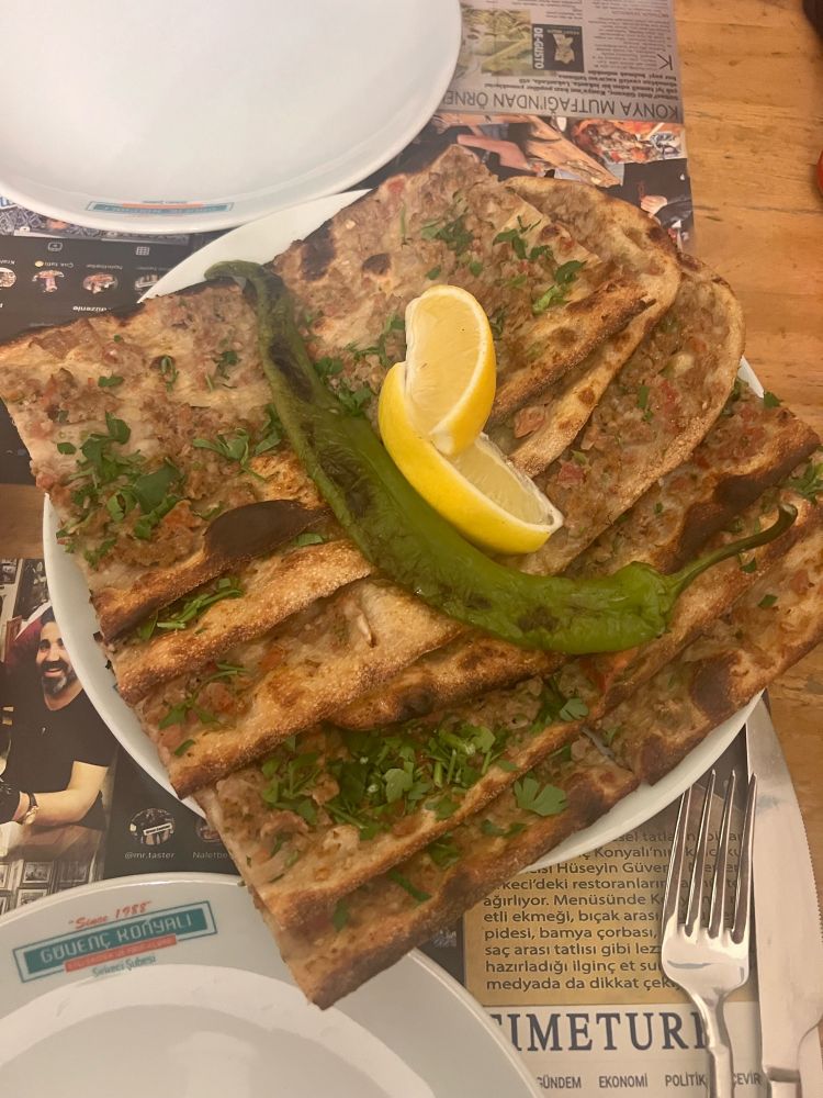 Konya pita with minced lamb, topped with two Lemmon wedges and a chilled green chilli. 