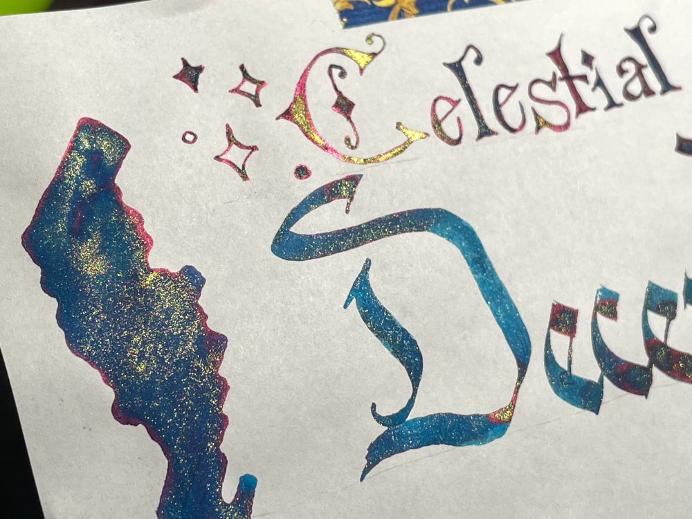 Photo: close up of a pretty swatch of ink, deep teal-green with gold shimmer and vibrant pink sheen