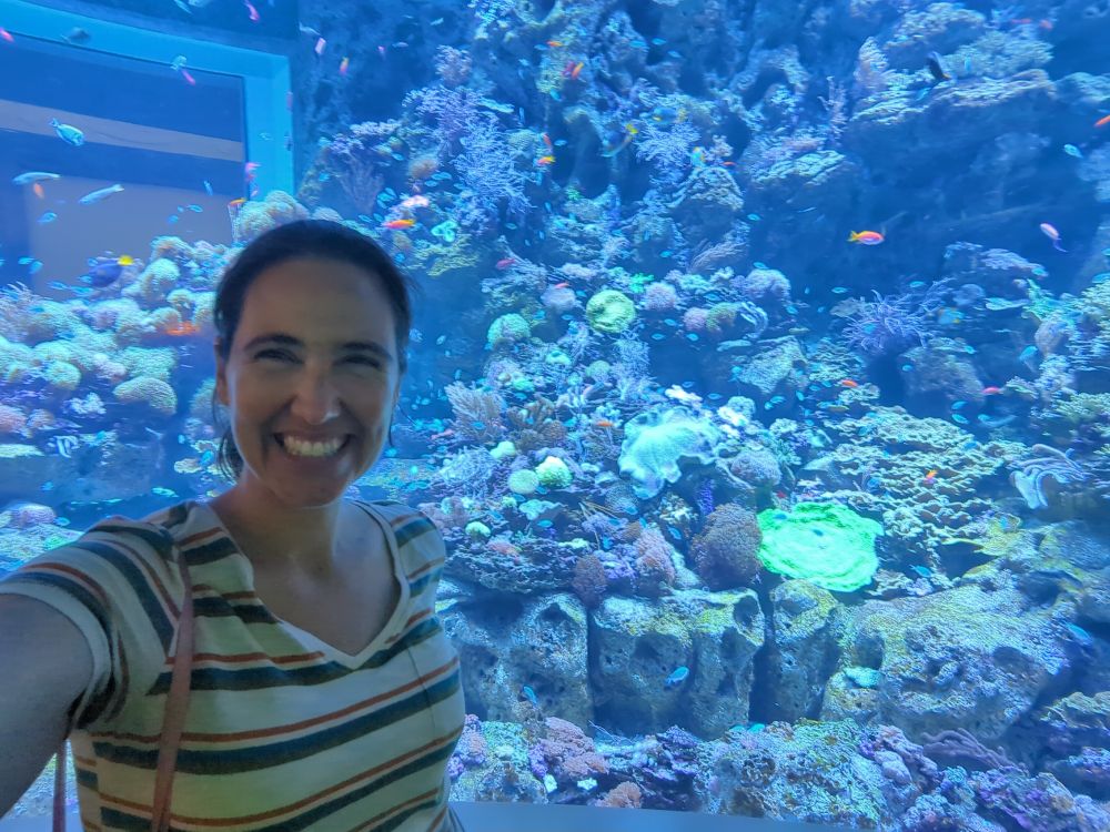 Me, smiling to camera in front of a reef tank