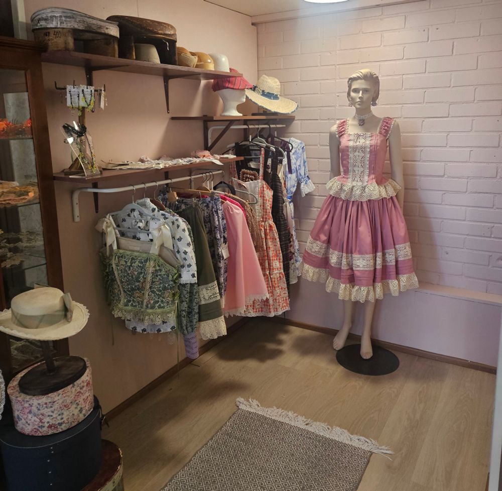 mannequin wearing a pink coordinate and shop railing with clothes