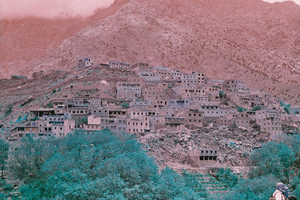 Village berbère devant une montagne avec le sommet caché par les nuages