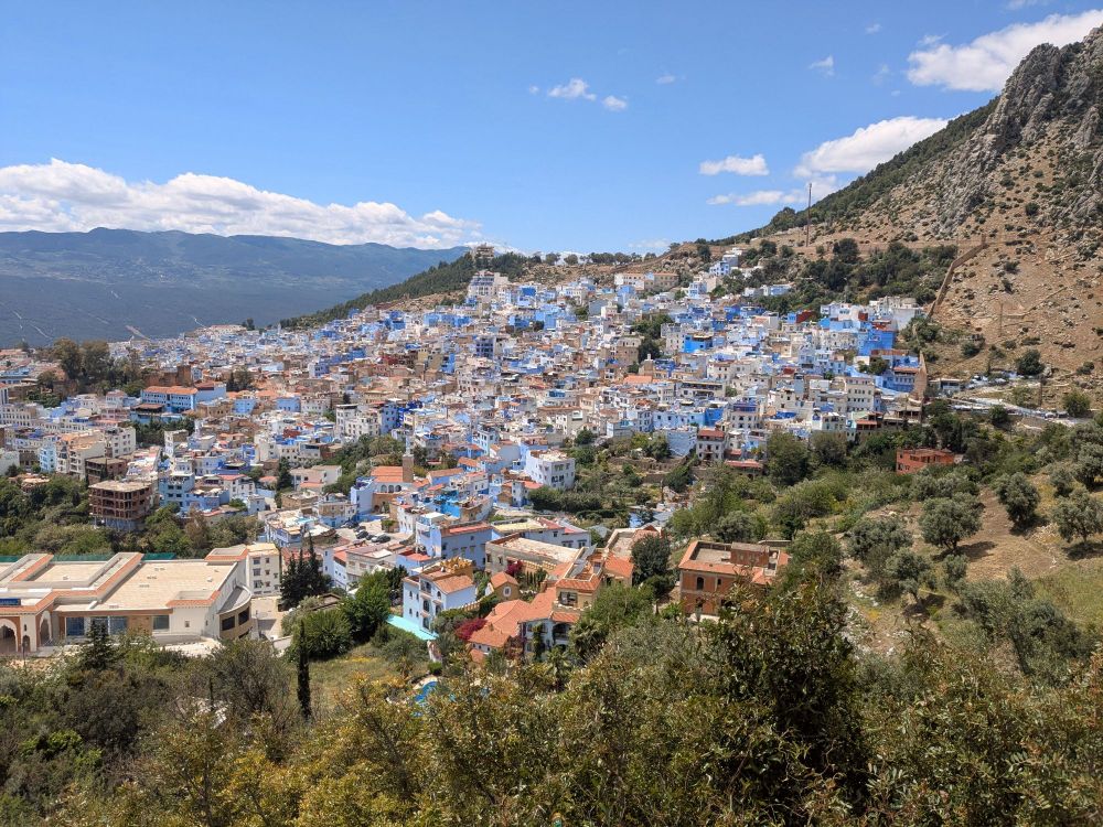 Village de Chefchaouen vu d'un haut, avec des maisons bleues et blanches dans la montagne 