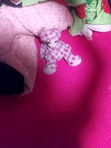 a stuffed animal is laying on top of a pink surface