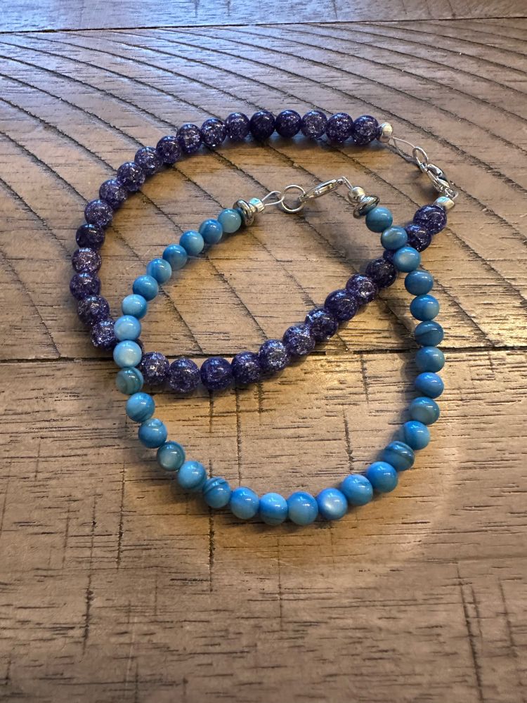 Two beaded bracelets, one purple and one blue.