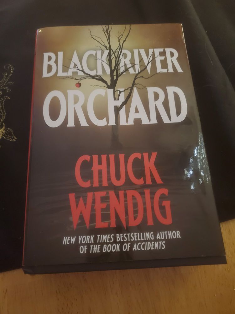 A hardback copy of "Black River Orchard" by Chuck Wendig. 