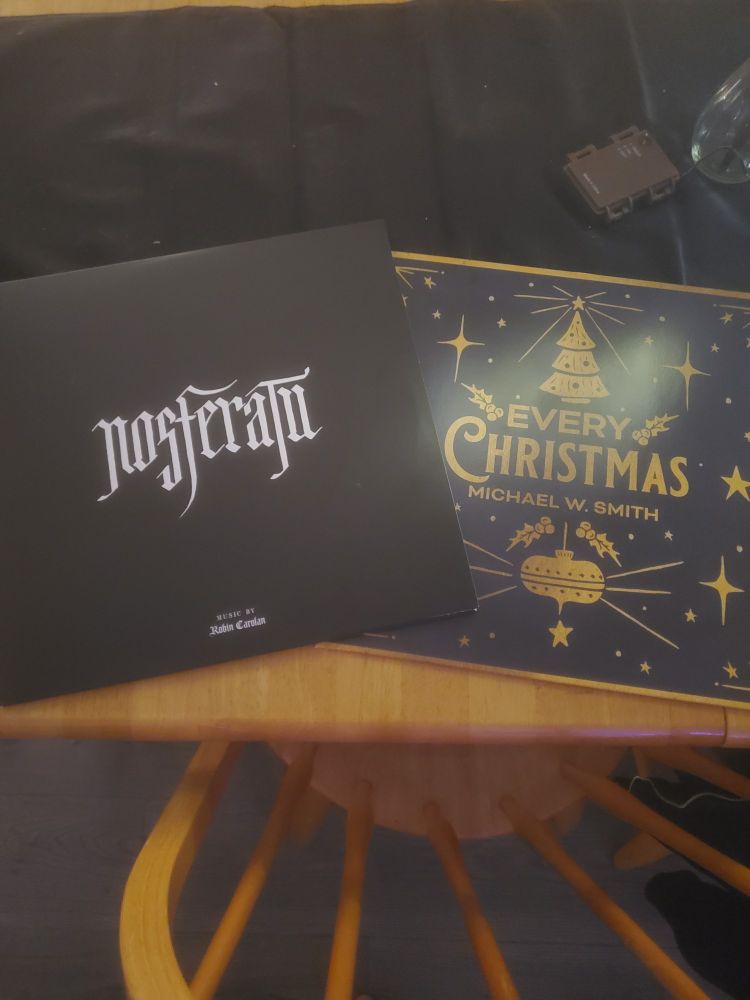 Two vinyl albums on a table - The score to the upcoming film Nosferatu, and Every Christmas by Michael W. Smith.