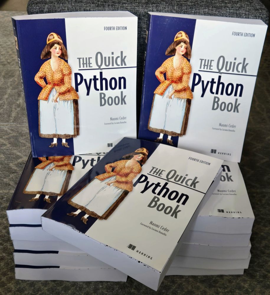 Several copies of the Quick Python Book, neatly stacked.
