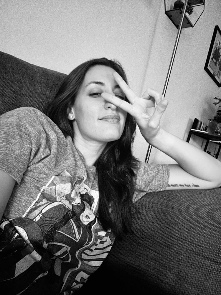 black and white photo of a girl giving the peace sign on a couch