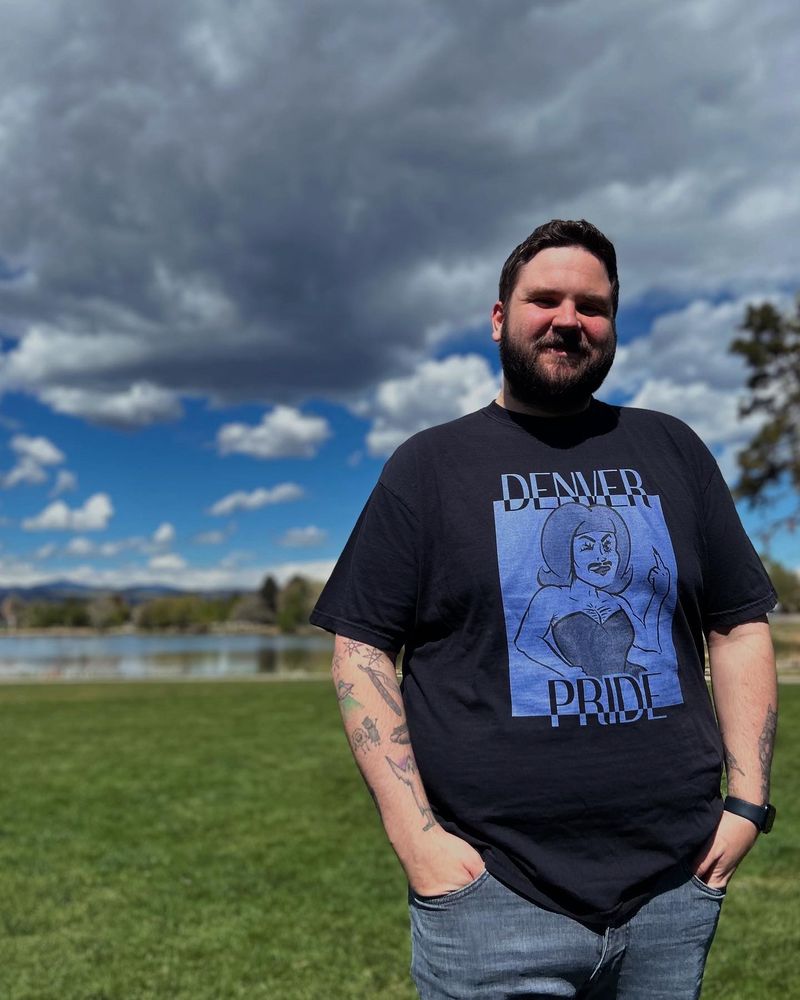 A man wears the “Rockies” version of the Denver Pride 2025 t-shirt