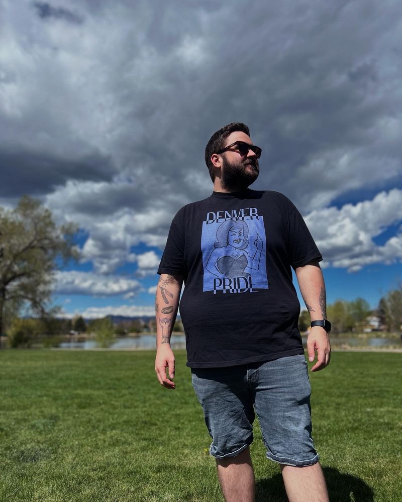 A man wears the “Rockies” version of the Denver Pride 2025 t-shirt