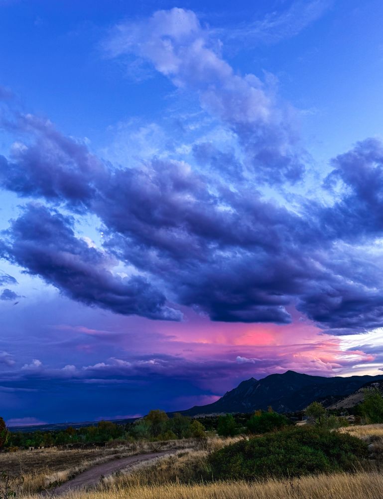 Dramatic storm clouds gathering over the Flatirons in Boulder, Colorado at dusk. A fiery red sunset glows from within the dark sky, illuminating the landscape in vivid, unexpected color. The scene captures that transformative moment when the sky shifts from intensity to awe — a reminder of resilience, beauty, and presence.

storm, storm clouds, dramatic sky, Flatirons, Boulder, Colorado, nature, outdoors, mountains, sunset, dusk, night sky, universe, stars, inspiration, wellness, well-being, mindfulness, stress relief, calm, reflection, nature is my therapy, emotional healing, resilience, inspiration quote, poetic caption, sky photography, landscape photography, nature photography, dramatic landscape, mindful living, beauty in nature, sunset inspiration, awe, photography by Eric Meleney, @redcranehealth
