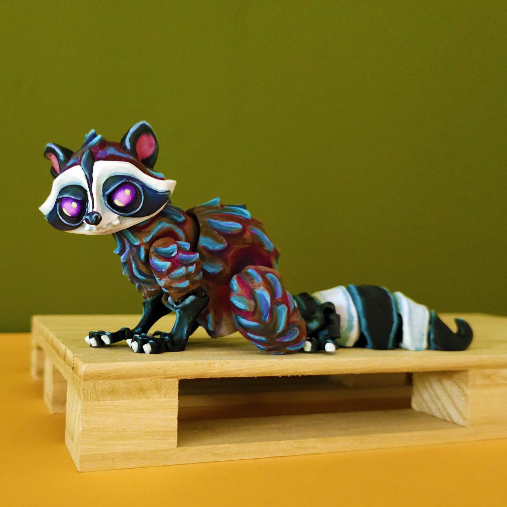 3d printed and handpainted raccoon sitting on a wooden platform, on a green background, looking at the camera from a side view