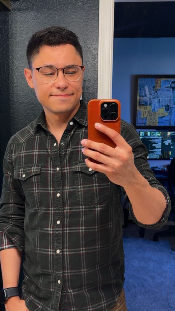 Picture of me standing in front of a mirror wearing a greed plaid shirt 
