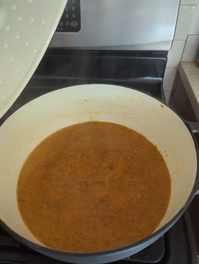 Picture of an open Dutch oven with completed tomato bisque steaming within