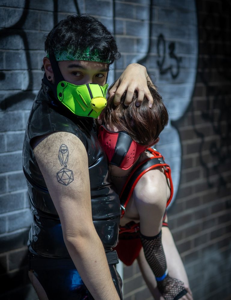A human-rubber-dog keeping pressing his hand down onto another human-dog's head