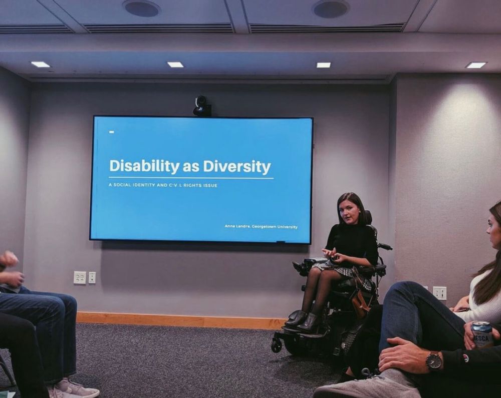 Anna presenting in front of a screen that says “disability as diversity”