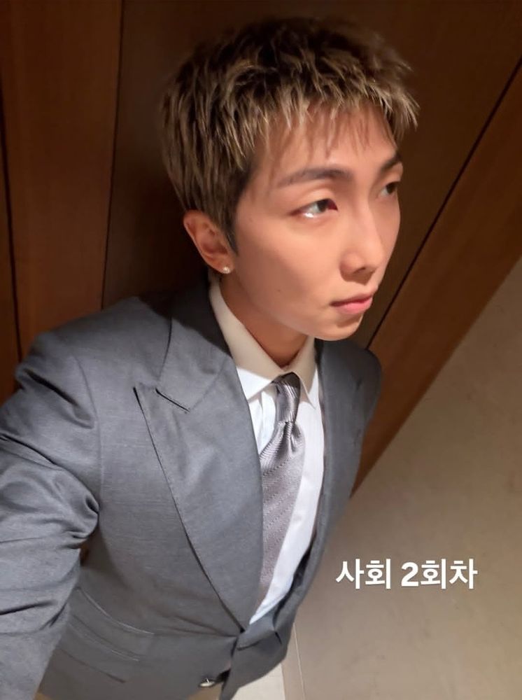 BTS RM in a silver-gray suit. Selfie in an enclosed space, with a Korean-language caption