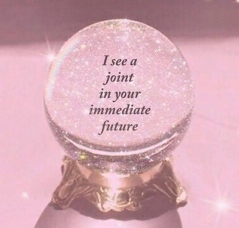 a sparkly crystal ball on top of a gold stand with a pink aura all about it and inside the ball it says “i see a joint in your immediate future” 