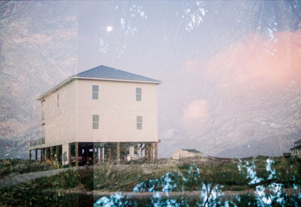 A beach house during sunrise with the overlay of a tree