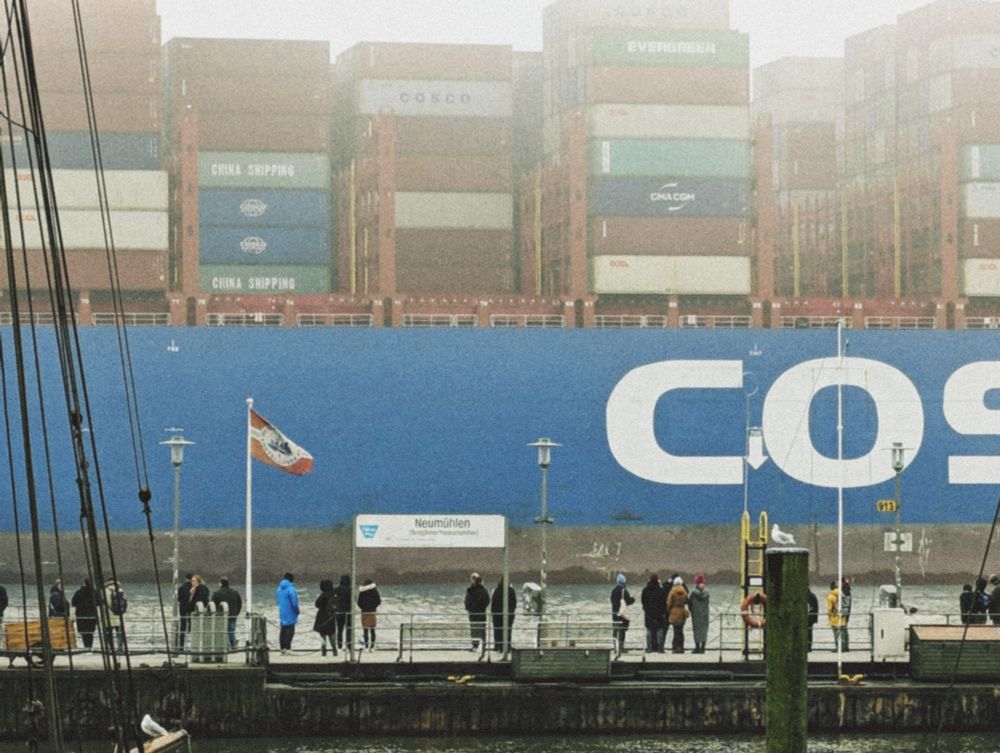 Hamburg, Neumühlen. Menschen beobachten ein Containerschiff