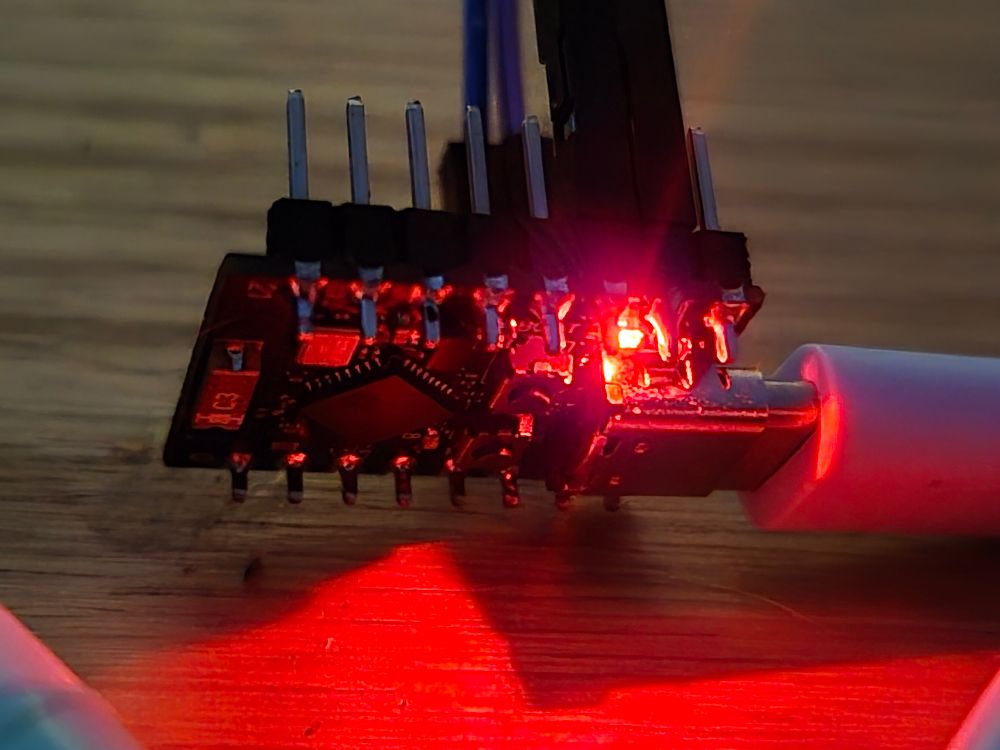 An ESP32-C3 supervision. It's attached to a usb C cable and its power light glows red.