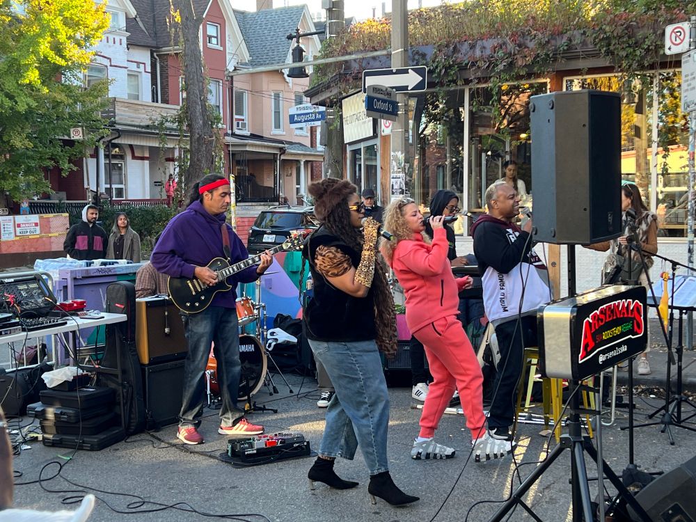 The Arsenals ska band - 3 singers and guitarist in frame - playing on an open street