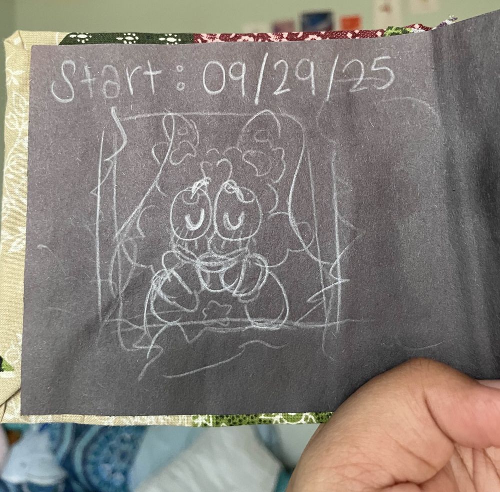 Inside cover of the sketchbook, the pages are black with a white colored pencil drawing of Comet looking out a curtained window, holding a cup, eyes closed, enjoying their day.