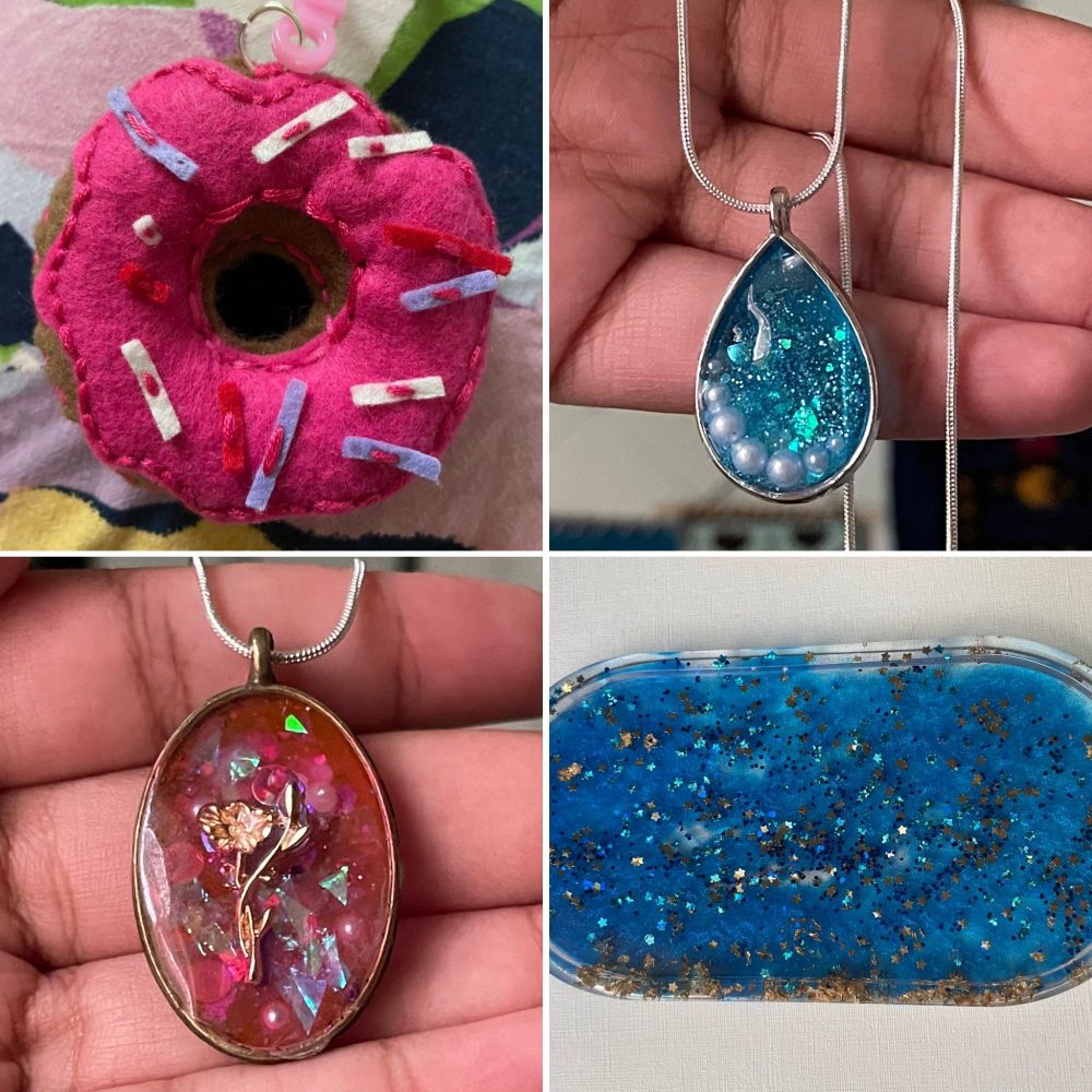 A 2x2 grid of art I made at library events. 

From left to right, top to bottom:

First row: A donut keychain; the donut is brown with pink frosting and stitches and scattered with red, white, and purple sprinkles. A pendant based on one of my OCs, Hallow. It's a glittery blue teardrop with small pearls lining the bottom.

Second row: A pendant based on one of my OCs, Eve. It's pinkish-red with lots of iridescent flakes in it and a gold flower in the middle. A resin trinket tray, it's blue and a bit cloudlike and filled with gold and blue stars. Some gold flakes line the bottom edge of the tray.