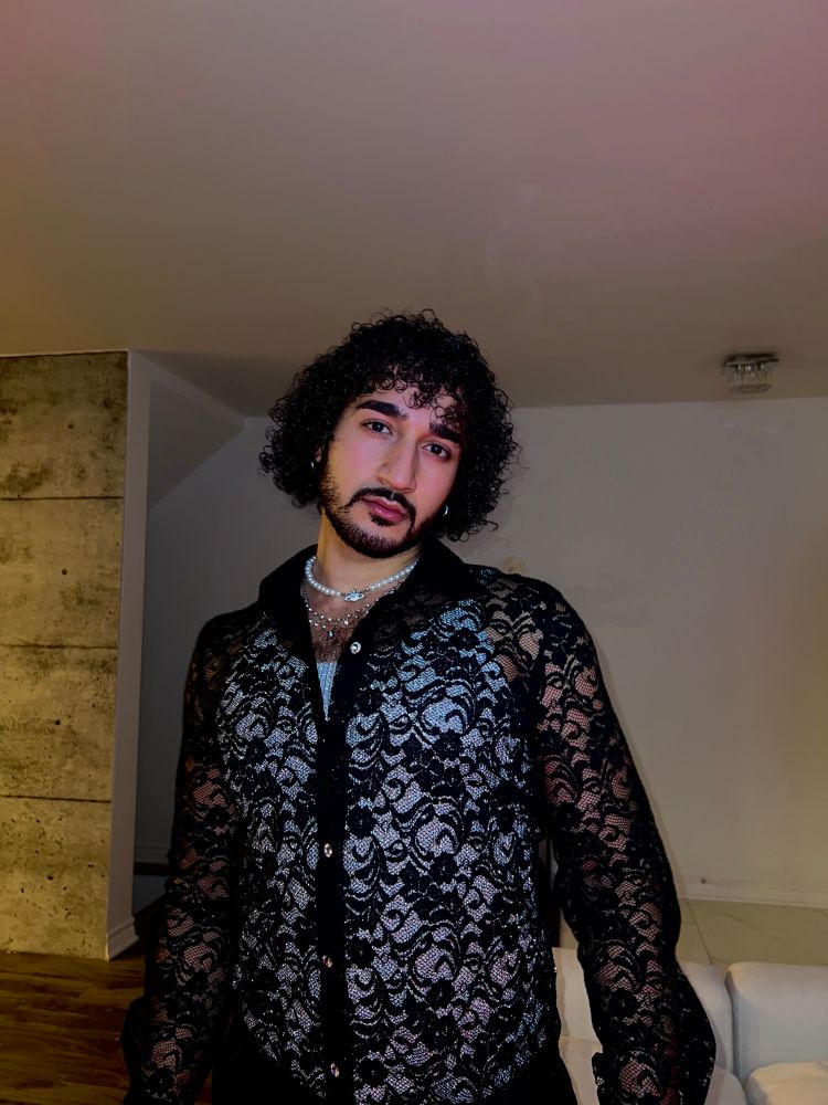 Selfie of me with a long sleeve lace top and a silver shiny tank top underneath. Posing with my curly hair & silver necklaces 