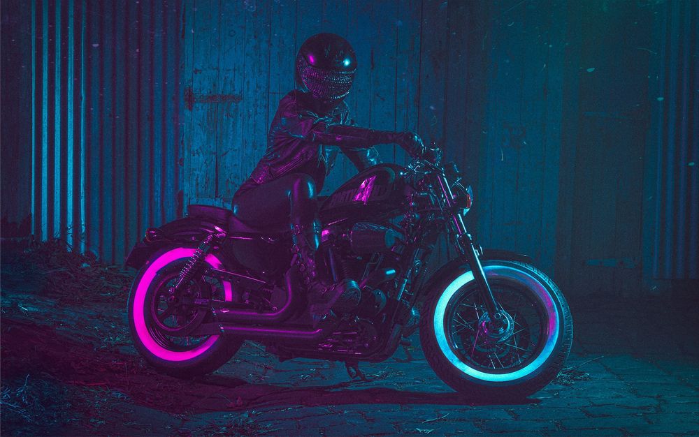 The same helmet wearing person sat atop a motorcycle.