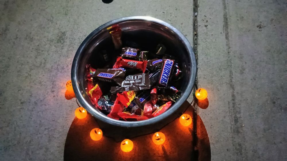 A bowl of candies ringed by tiny light up jack-o-lanterns.