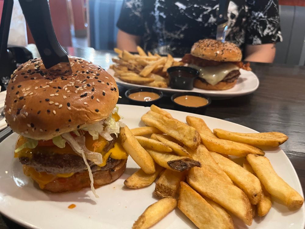 two big burgers sitting on a restaurant table