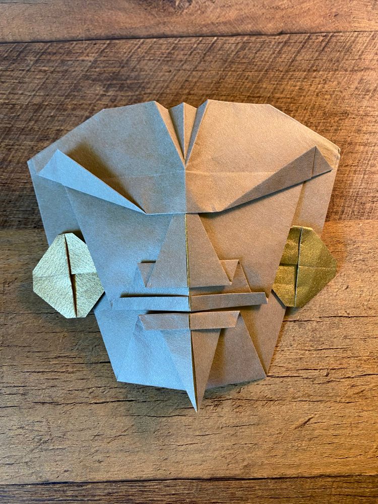 Origami mask made with duo paper, a matte taupe on one side for the face and gold foil on the other side for the earrings. 