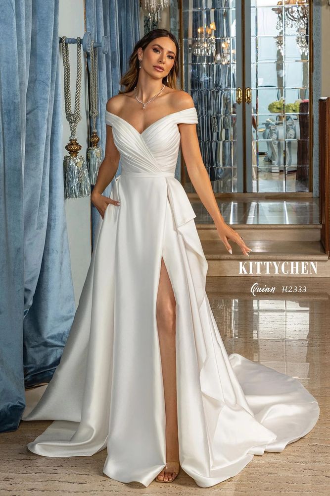 An elegant, satin Kitty Chen dress, off the shoulder with a ruched bodice, and a beautiful flowing skirt with a slit and train.