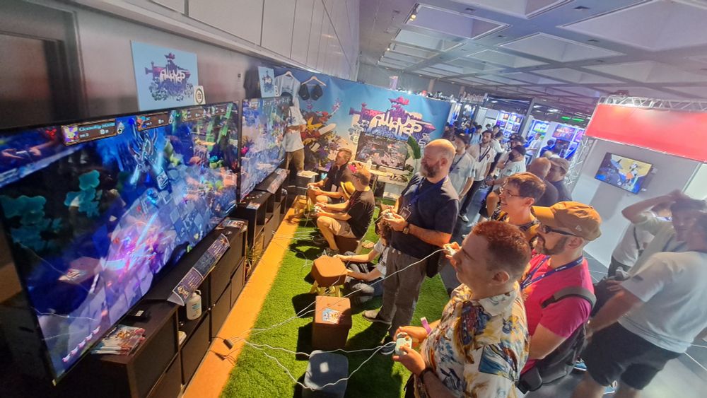 The AWAYSIS booth at Bitsummit with green astroturf flooring 