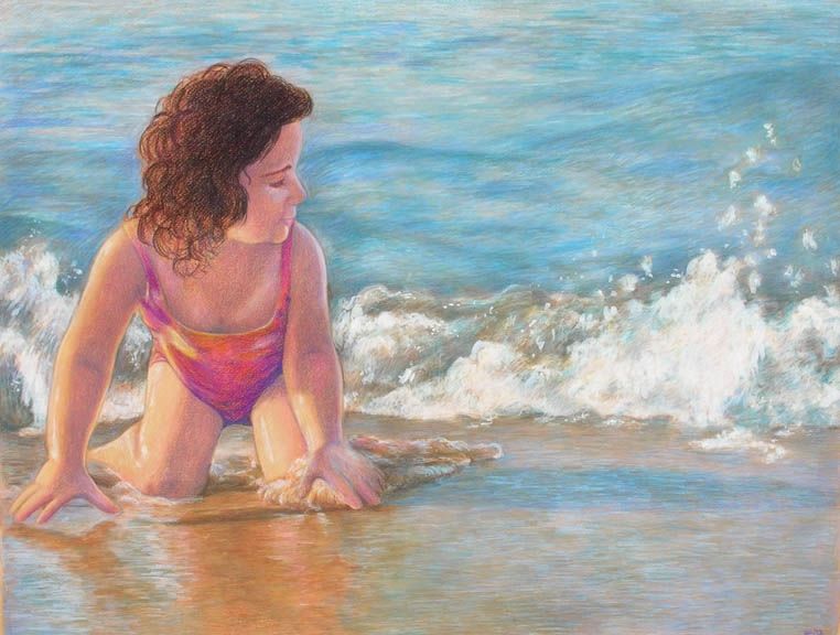 a toddler girl in a pink swimsuit crouched on the beach as waves crash behind her