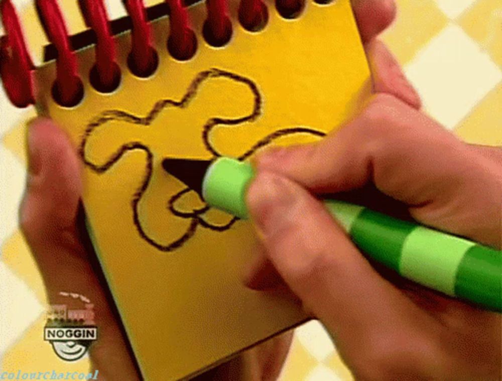 a person is drawing a flower on a notepad with a green marker