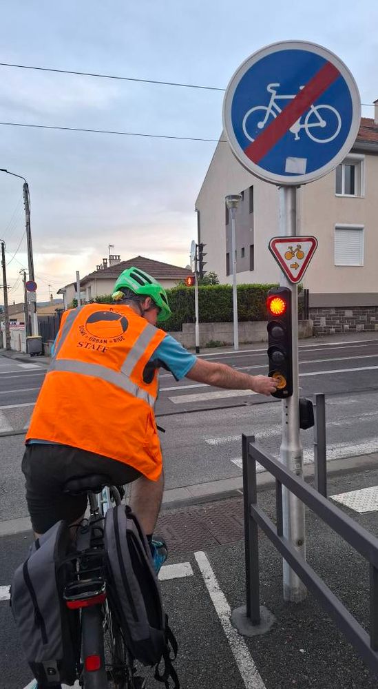 photo d'un cycliste de dos appuyant sur le bouton de demande de feu vert