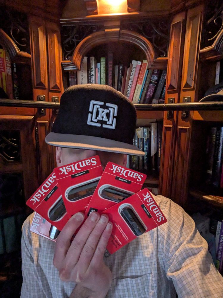 A person in a hat with several identical USB thumb drives.