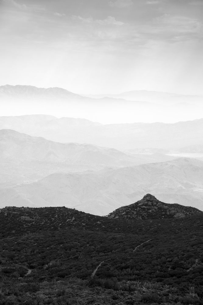 A black and white photograph of the view looking out from the Laguna Mountains, East County San Diego.  In the distance is a valley in Anza Borrego Desert State Park, layered with many hills.