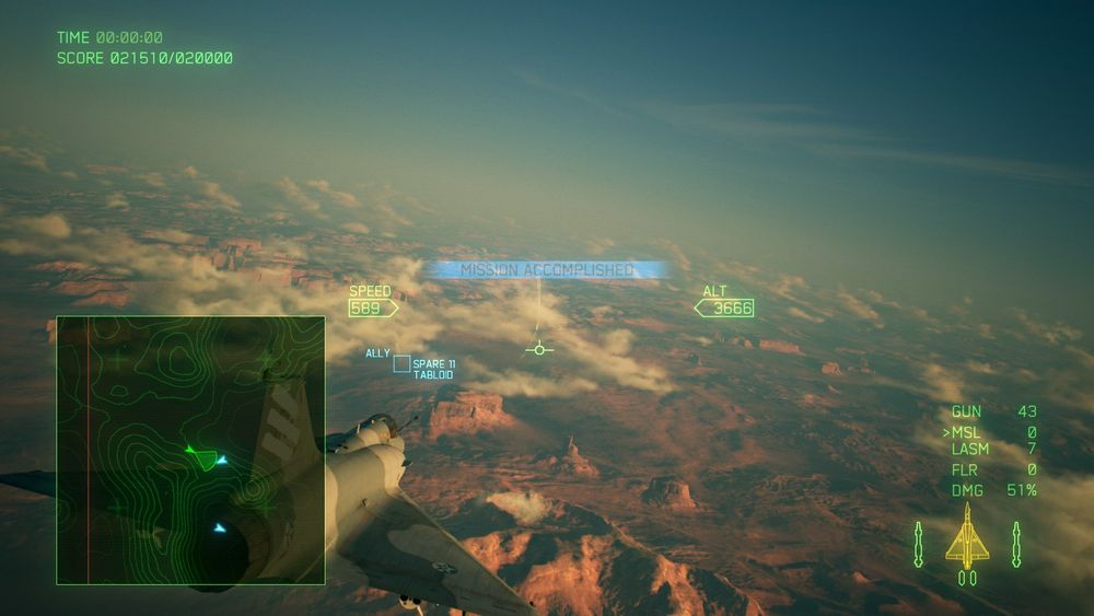 Screenshot from Ace Combat 7 showing a fighter jet flying above a desert canyon landscape at sunset. The HUD displays "MISSION ACCOMPLISHED" in the center, with the aircraft at 3,666 altitude and 589 speed. The minimap and stats show remaining weapons, 51% damage, and an ally labeled "SPARE 11 - TABLOID" ahead.
