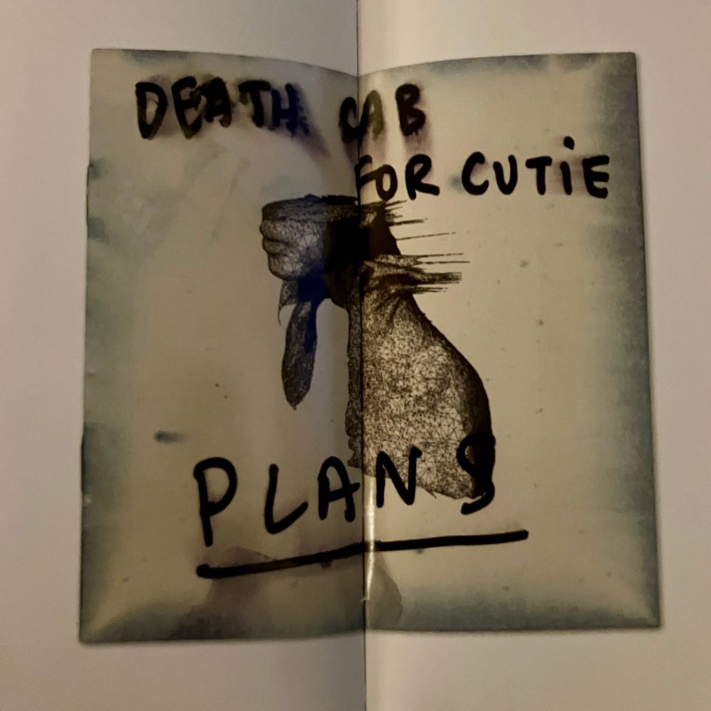 photograph of the cover of coldplay’s 2002 album ‘a rush of blood to the head’, with ‘death cab for cutie — plans’ scrawled on in black sharpie 